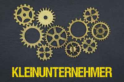 © magele-picture - stock.adobe.com Zahnräder und Schriftzug Kleinunternehmer